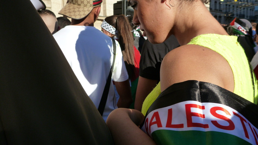 Una chica algo triste, instantes antes de arroparse los hombros con la banderola palestina
